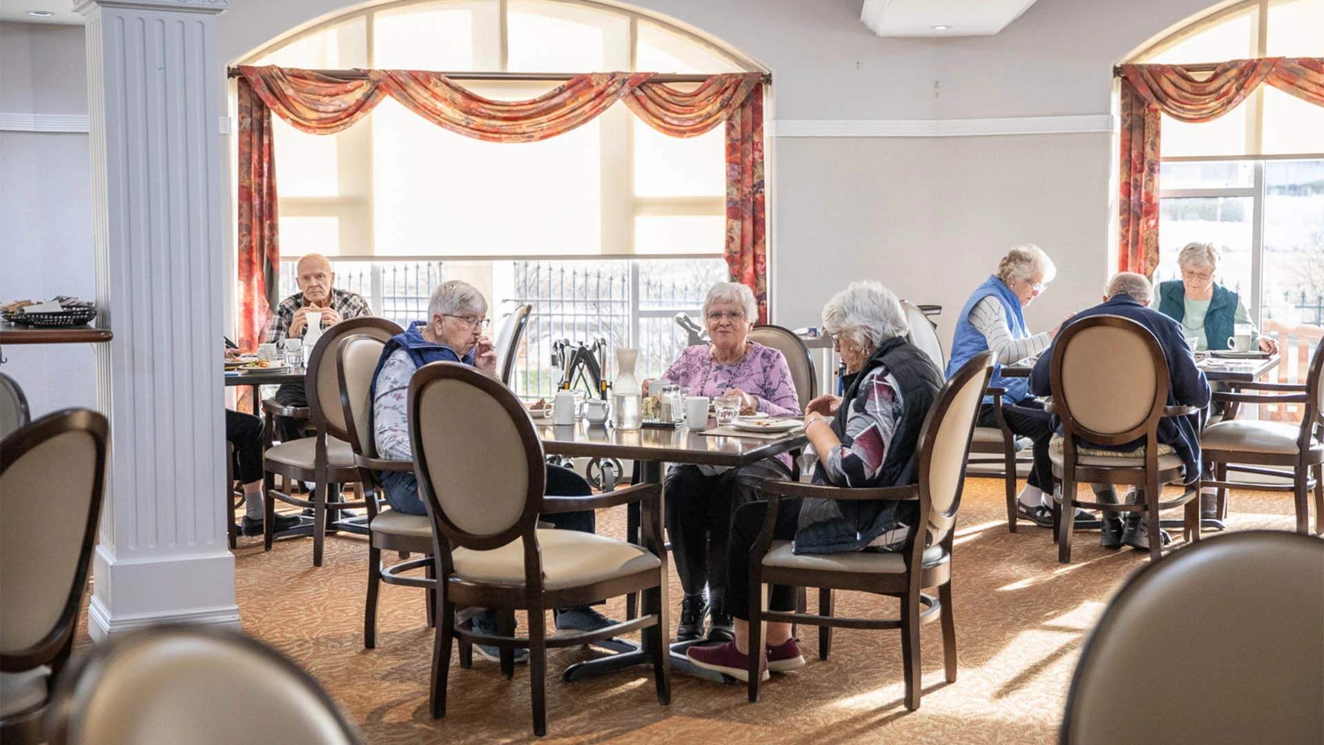 seniors at a dining room eating and laughing