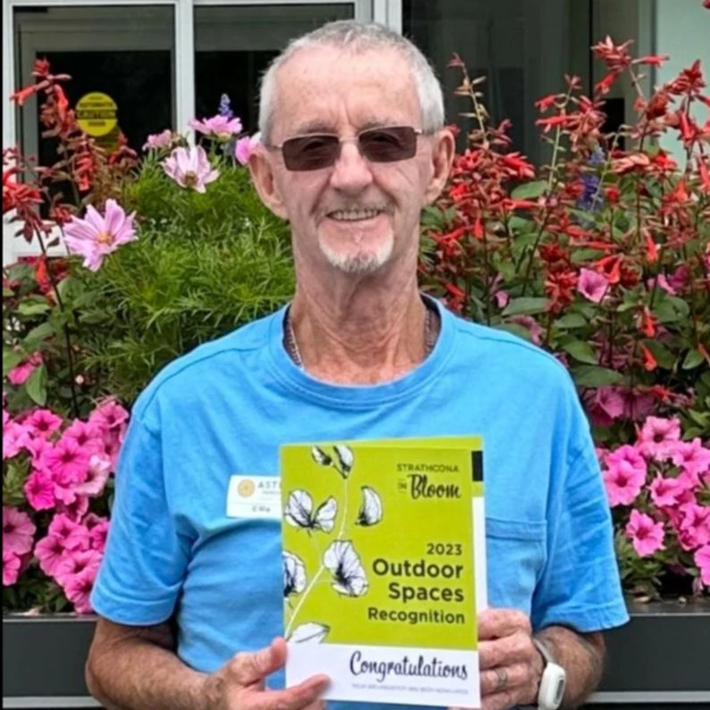 Senior man standing with a card