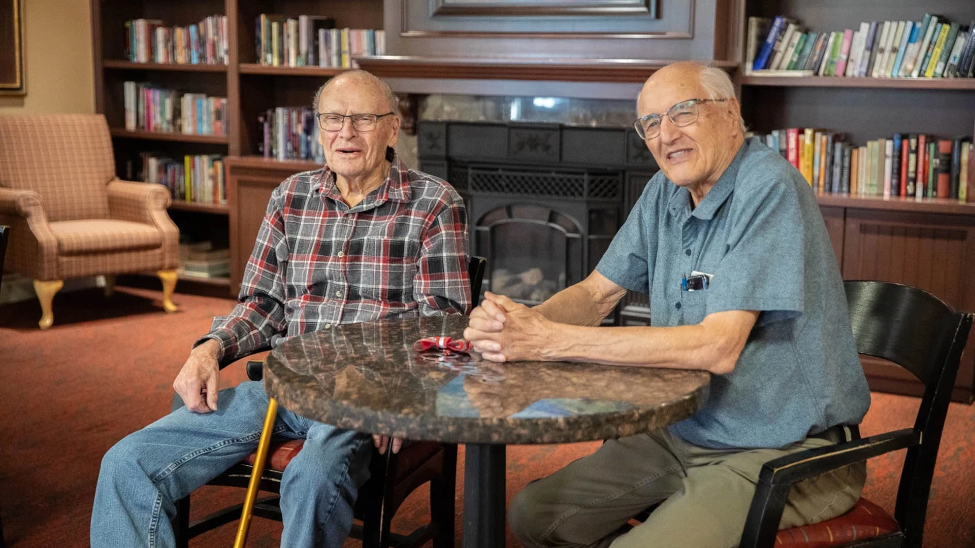 two senior males sitting at a round table